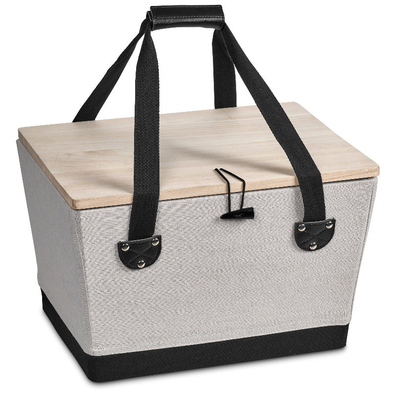 Boxy picnic basket with wooden lid and black handles on white background