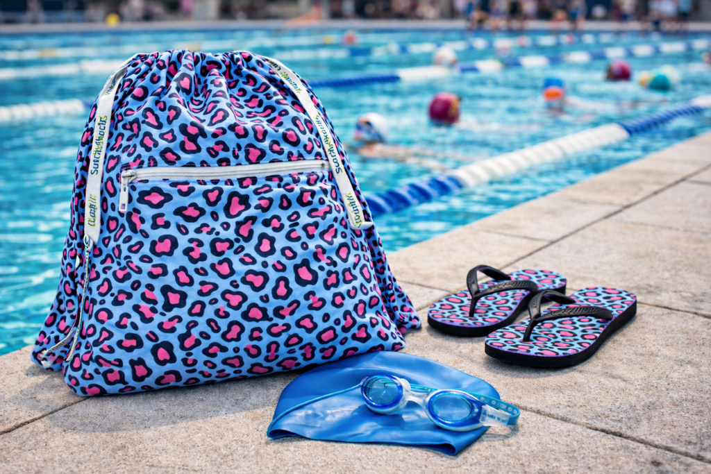 Leopard print TowelTote, blue swim cap, and flip-flops by a pool.